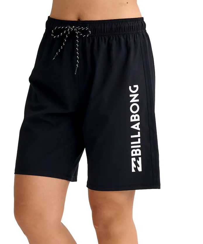 Black Billabong swim shorts with a white vertical logo and a drawstring waist on a model.
