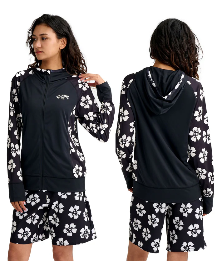 Front and back view of a woman wearing a black zip-up hoodie with white hibiscus prints on sleeves and matching shorts; logo on the chest.