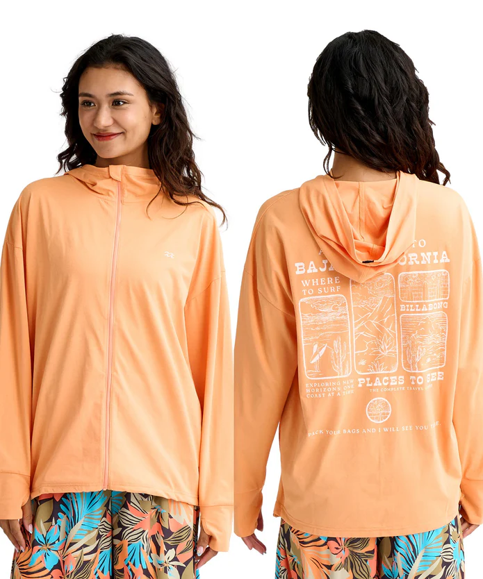 Two women wearing peach-colored hoodies: one faces front with a small white logo, the other shows the back with a white graphic print and text.