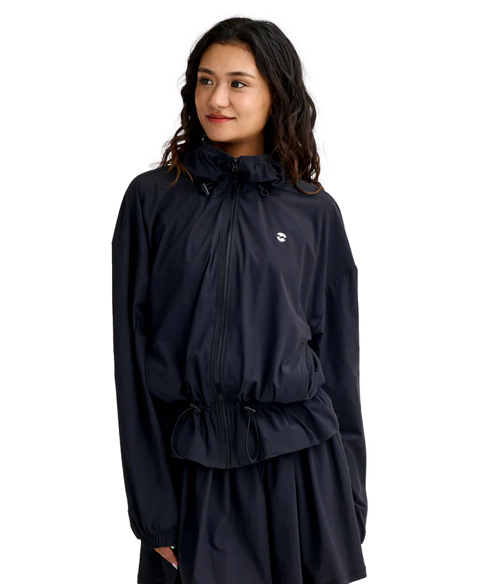 Woman wearing a black windbreaker with a front zipper and adjustable waist drawstrings.
