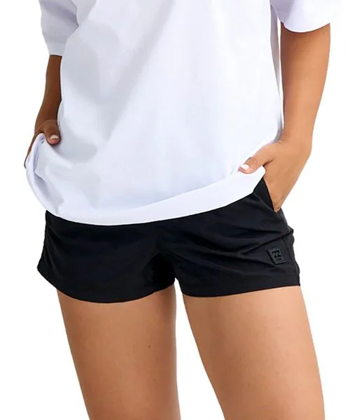 Person wearing a white T-shirt and black athletic shorts with pockets, standing with hands in pockets.