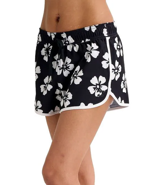 Black swim shorts with white hibiscus flower print and white trim, shown on a model.3A7️