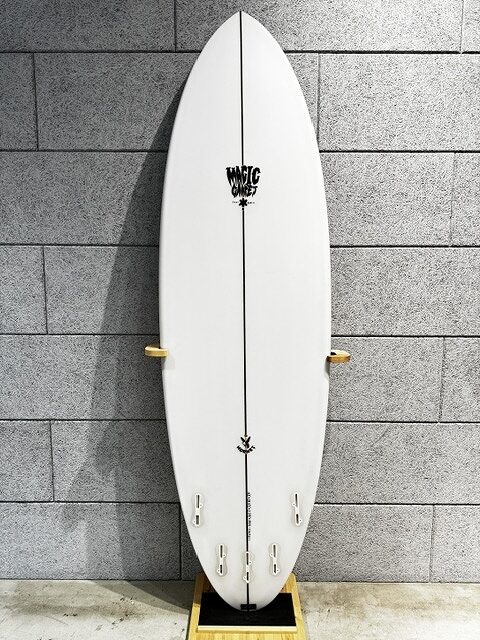White surfboard standing upright on a wooden stand against a gray brick wall.