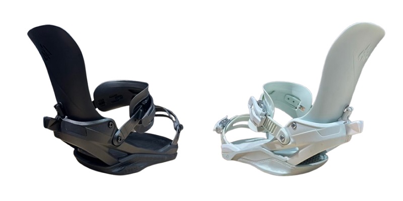 Pair of snowboard bindings, one black and one white, with highbacks and ankle straps visible down the sides.