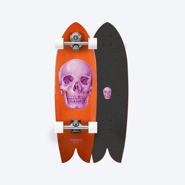 Two longboards standing side by side: left orange deck with a large purple skull and white wheels, right black deck with textured grip tape and a small skull graphic.