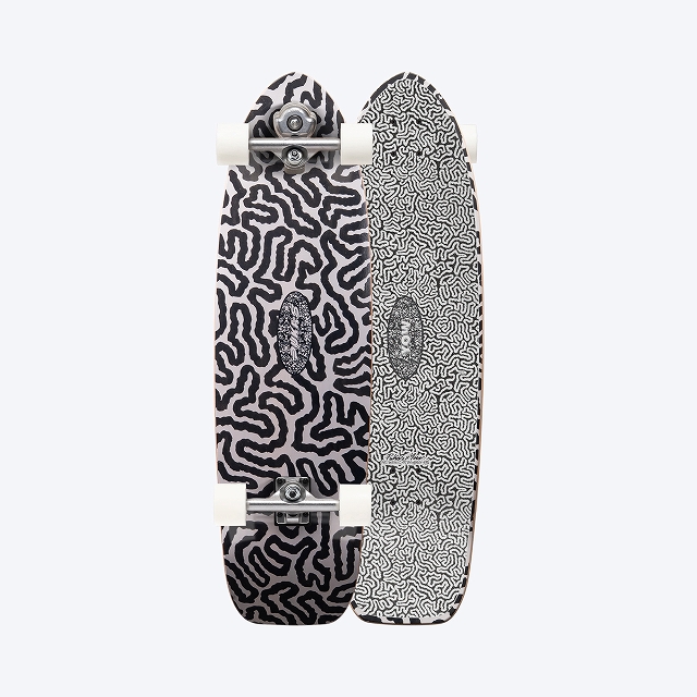 Two skateboards with black-and-white maze patterns standing side by side, showing silver trucks and white wheels against a light background.