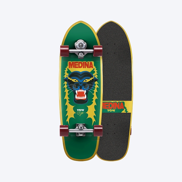 Two Medina Yow skateboards shown side by side; front deck is green with a snarling wolf graphic and red wheels, back deck has grip tape and yellow trim.
