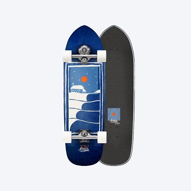 Blue longboard with nautical graphic (waves and orange sun) on the left deck, white wheels, and a dark grip-tape right deck side.
