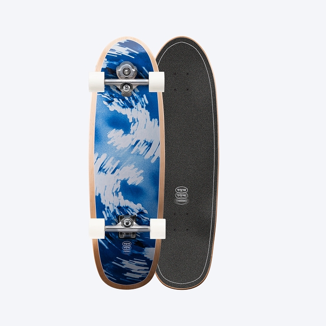 Two vertically aligned skateboards side by side: left deck with a blue wave graphic and white wheels, right deck with black grip tape.