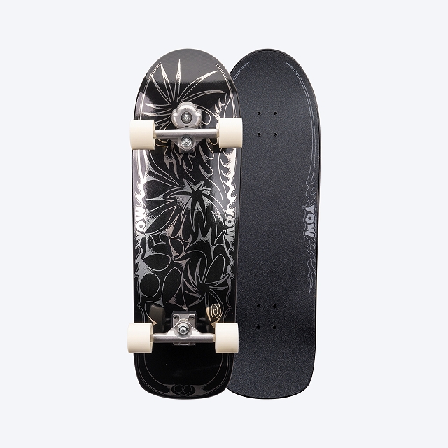Two-sided black longboard: one side features a white floral graphic with white trucks and cream wheels; the other side has grip tape.