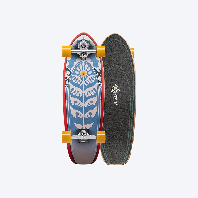 Two longboards stacked side by side: left a blue deck with white floral pattern and yellow wheels; right a black grip-tape deck with a small white flower logo.