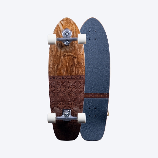Two skateboards stacked side by side: one with a wood-grain and brown patterned deck, the other with blue grip tape and white wheels visible.