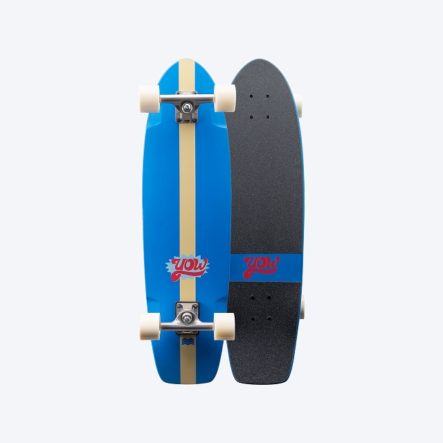 Two longboards stacked side by side: blue deck with a beige center stripe and white wheels, and a black grip-taped deck with a blue accent and red logo.
