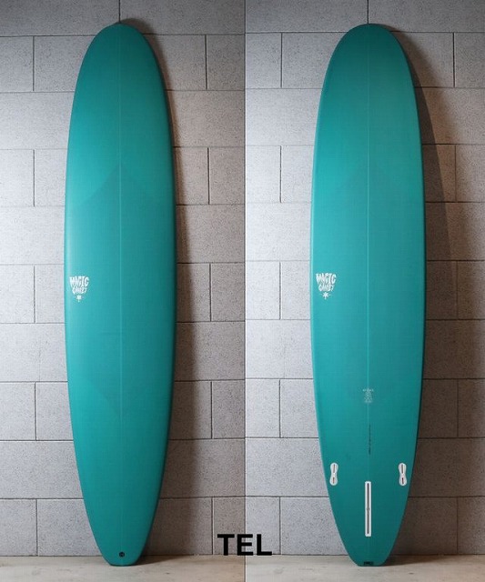 Two teal surfboards leaning against a gray tile wall, shown from front and back perspectives side by side in a showroom or storage area.