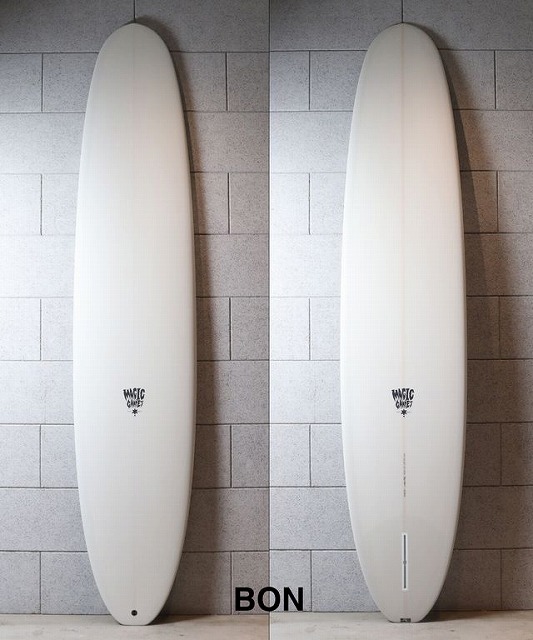 Two white surfboards leaning against a gray tiled wall, side by side, with small logos near the middle; 'BON' printed on the floor between them.