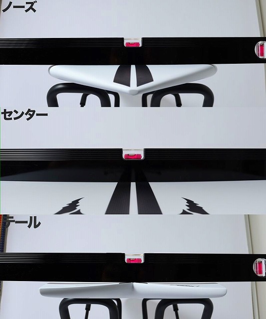 Stack of white boxes with black bands and pink tabs revealing parts of a white and black office chair frame.