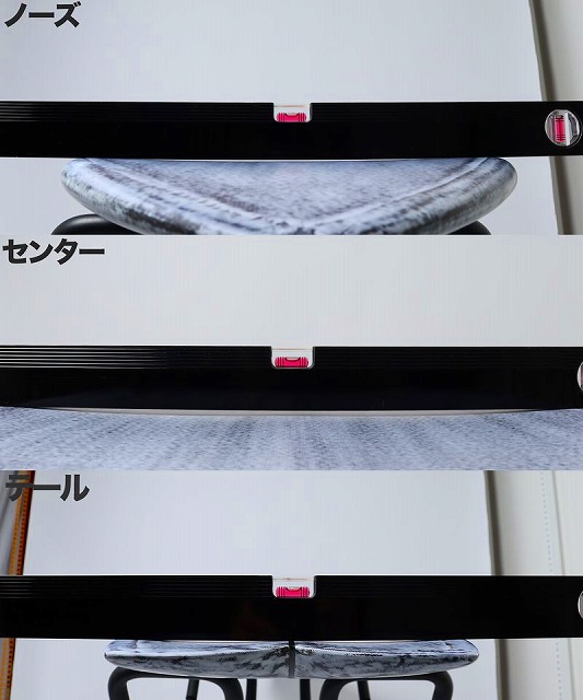 Close-up of a display with three gray stones balanced on black horizontal bars, separated by pink markers; Japanese labels ノーズ (nose), センター (center), and チール appear on the left.