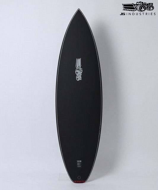 Black surfboard standing vertically against a light wall, with the JS Industries logo visible in the corner of the frame.