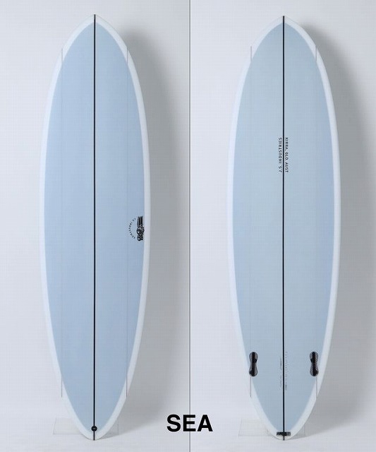 b-H3qODTmQ - SHOP NEWS | ムラサキスポーツオンラインストア 通販 Two light-blue surfboards standing upright against a light wall, white rails and black stringers, 'SEA' text at the bottom center.