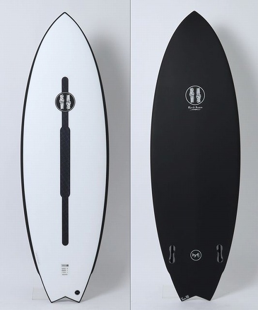 Two surfboards on display: left is white with a black edge and a central traction pad; right is black with a white logo near the center.