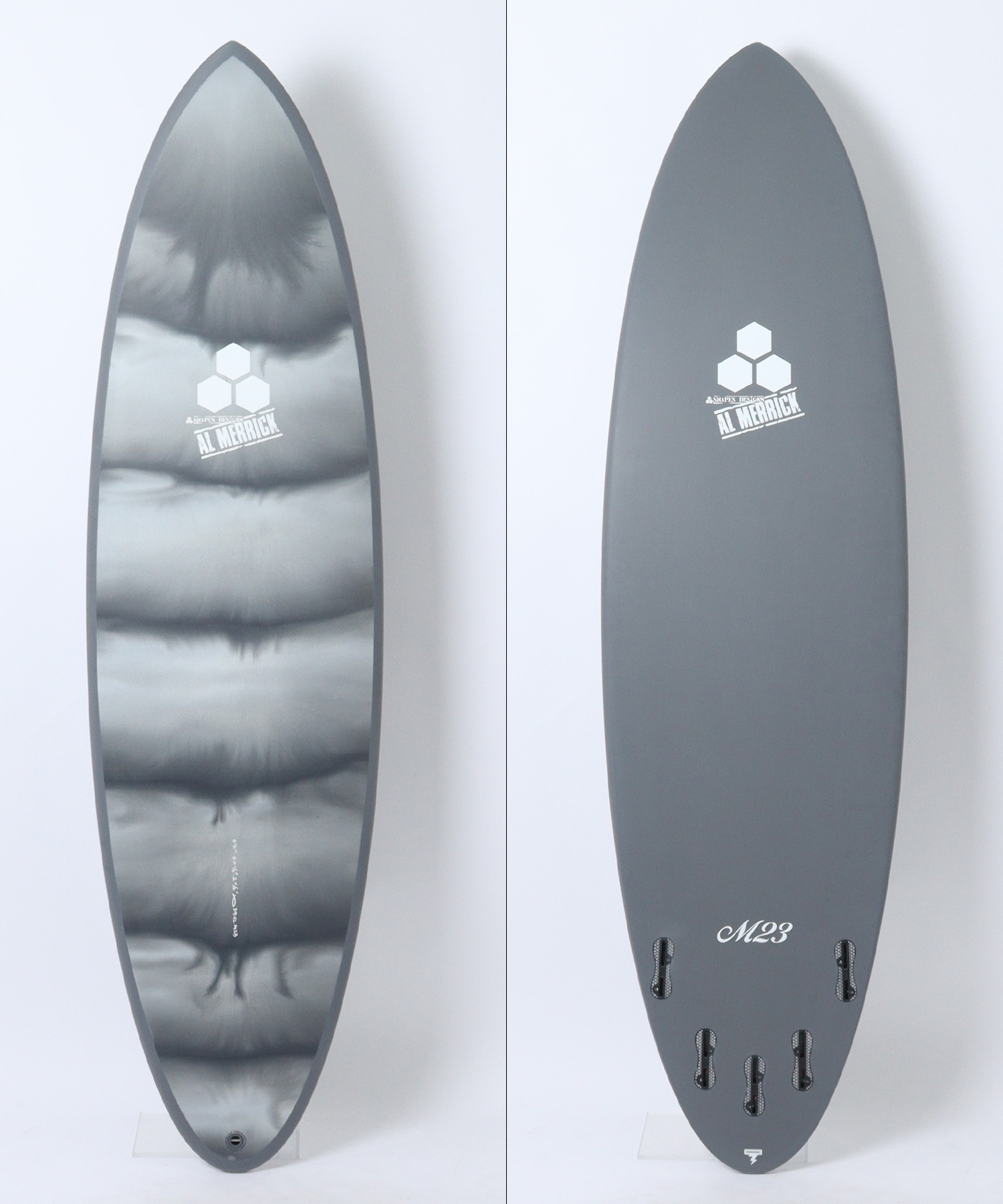n22821101010002_sub01 - SHOP NEWS | ムラサキスポーツオンラインストア 通販 Two views of a snowboard: left shows a glossy metallic top with cloud-like patterns and a hex logo, right shows a solid gray bottom with a hex logo and 'M23' near the tail.