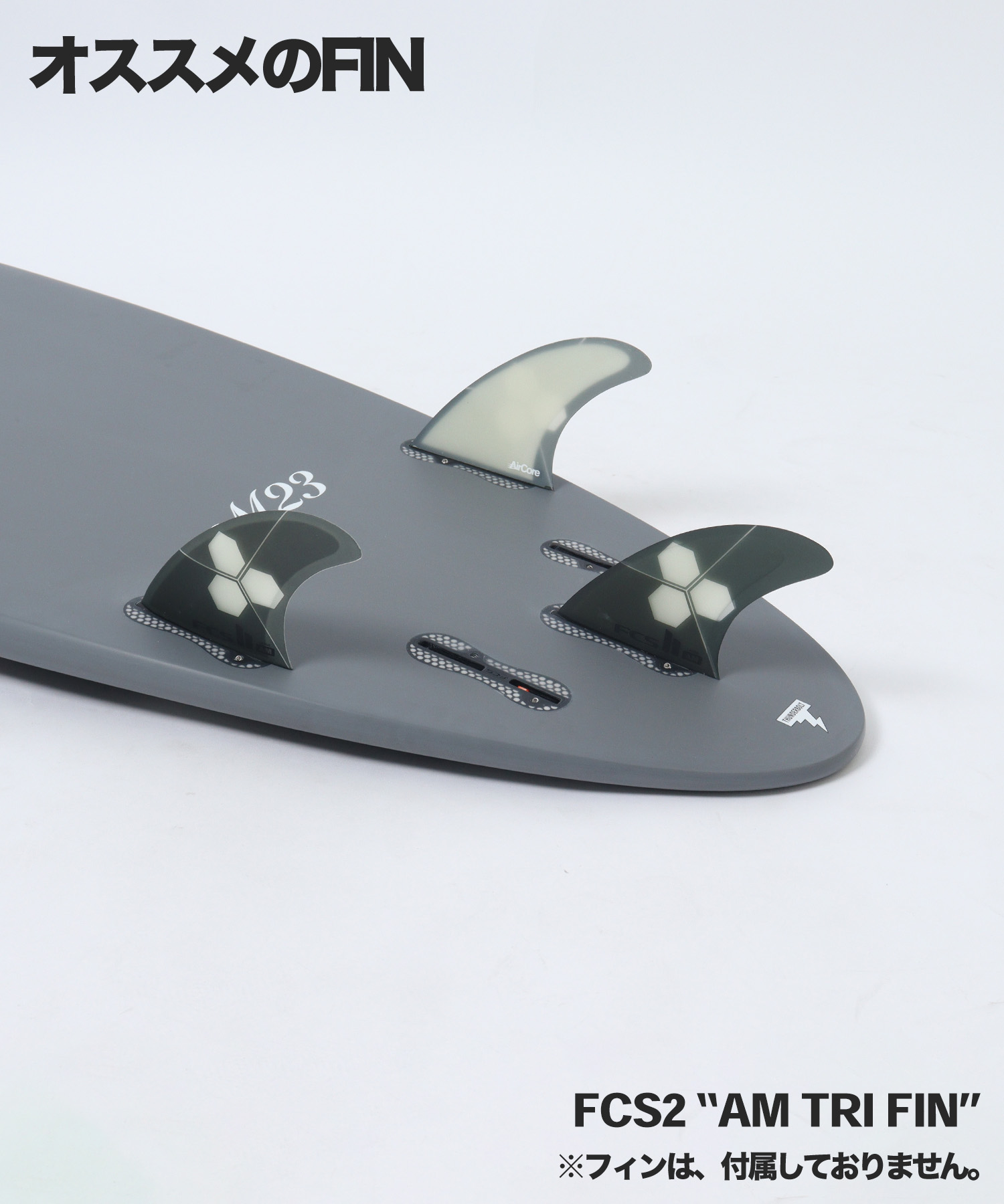 n22821101010002_sub05 - SHOP NEWS | ムラサキスポーツオンラインストア 通販 Close-up of a gray surfboard showing a three-fin setup: a translucent center fin and two darker side fins with hexagon logos (AM Tri Fin).