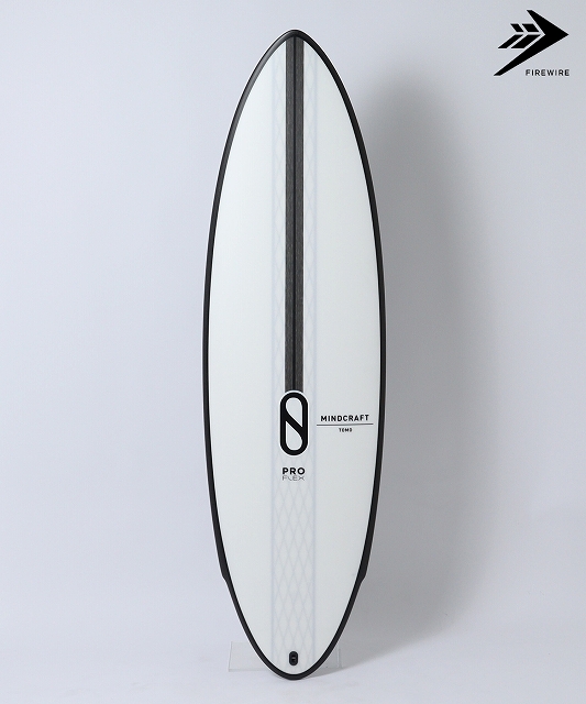 White surfboard with black rails standing upright against a light background; features Mindcraft branding and a Firewire logo in the corner.