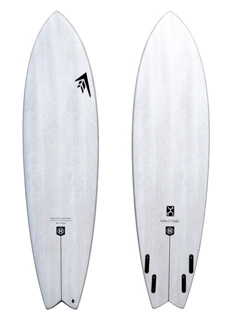 Two white surfboards with subtle gray grain stand upright side by side; each has a small black logo near the center and fin boxes toward the tails.