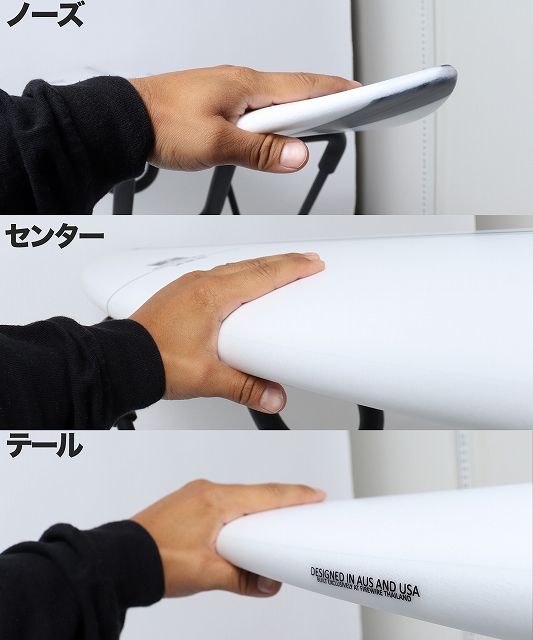 Close-up of a hand gripping the nose of a white surfboard.