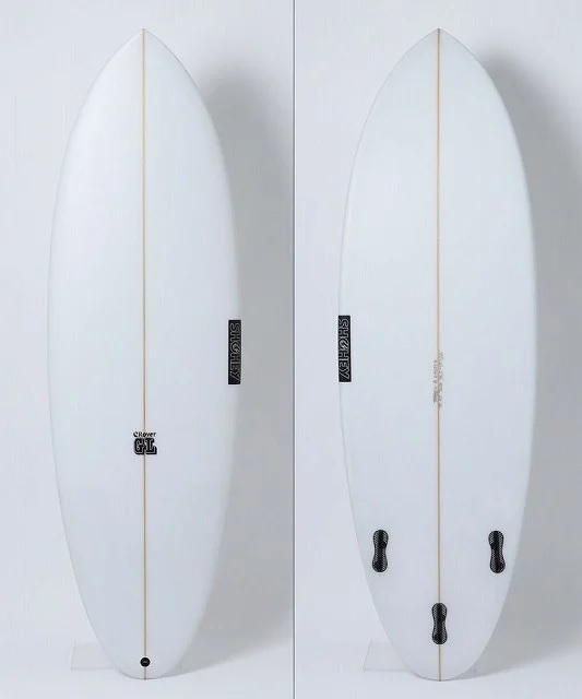 Two white surfboards with brown center stringers leaning upright against a light wall; both have black logos and fin-box hardware near the tail ends, side by side.