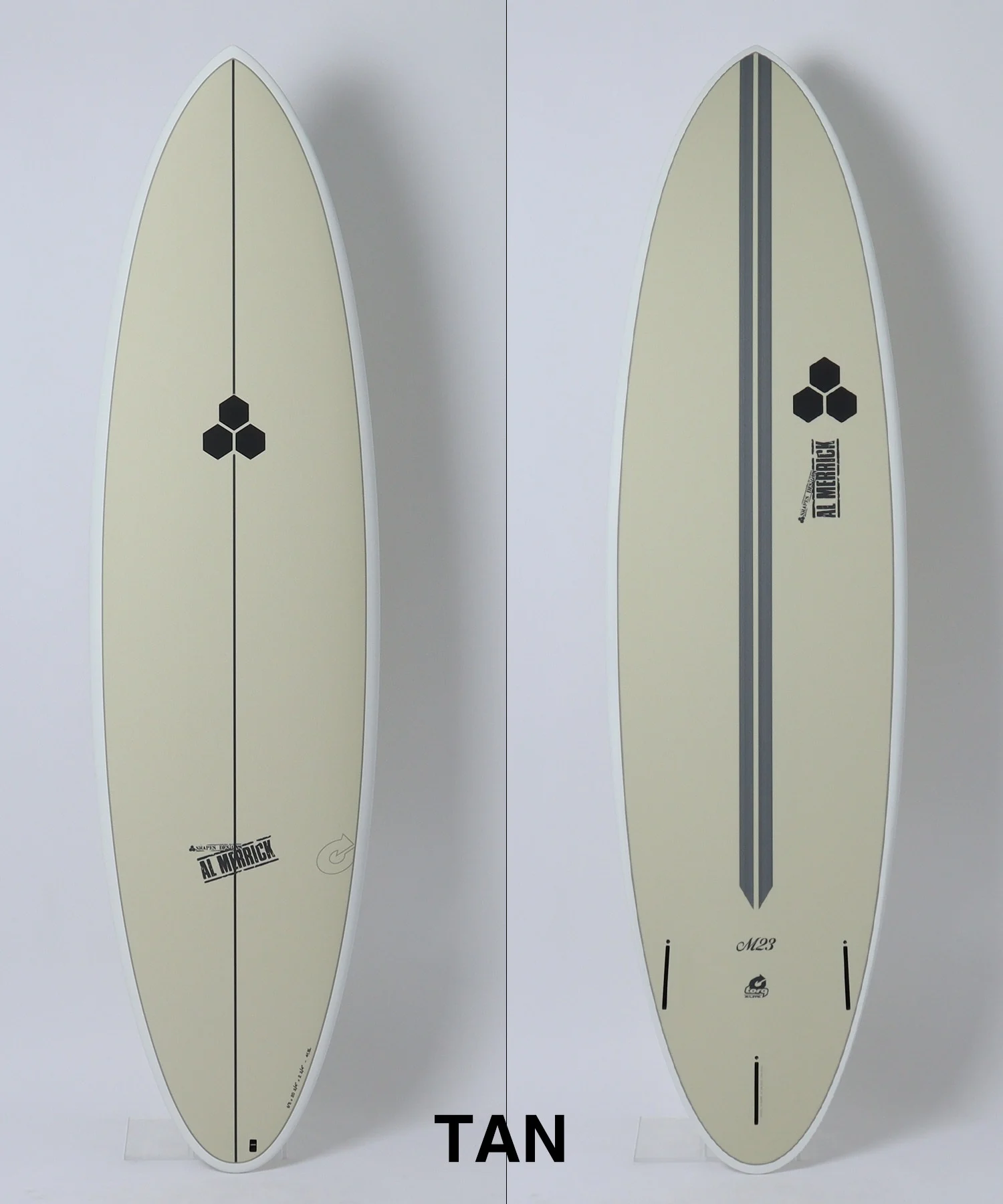 Two views of a tan surfboard: left side shows the front with a single black center stringer and a small hexagon emblem; right side shows the back with a double center groove and the hexagon emblem near the tail.