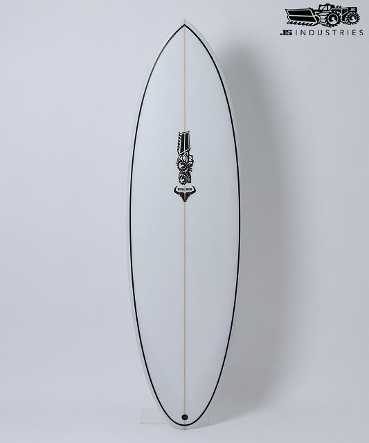 Full-length white surfboard with a light wooden stringer, black rail outline, and a small central emblem, standing upright against a plain wall.