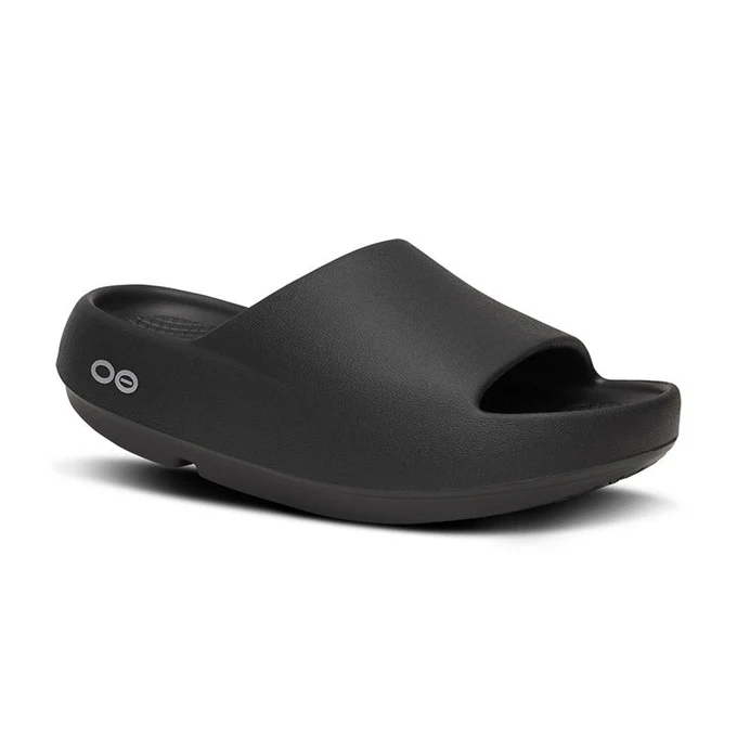Black slip-on sandal with a wide matte strap and low platform sole, logo on the outer heel.
