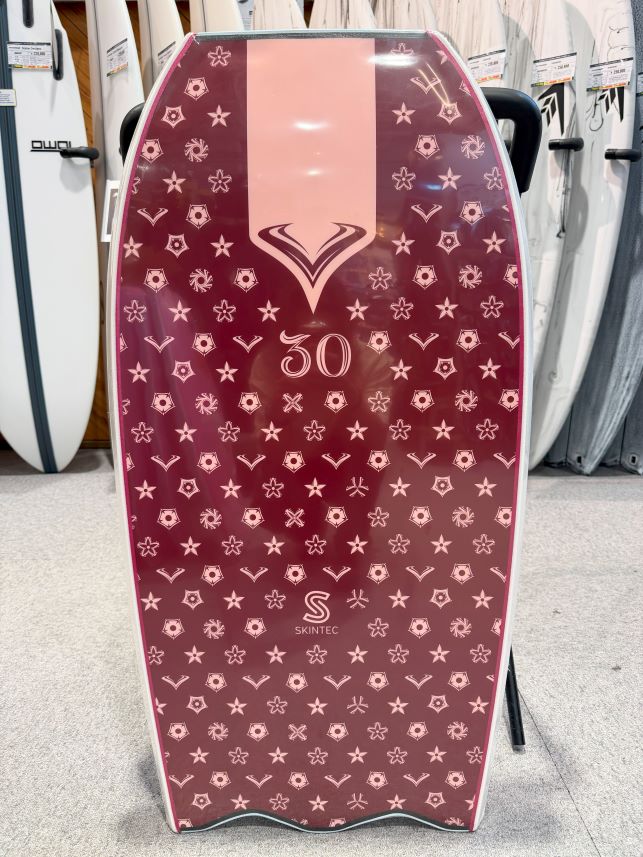 Pink-to-maroon stand-up board with a large central pink stripe, repeating star and geometric patterns, and the number 30; SKINTEC logo at the bottom edge.