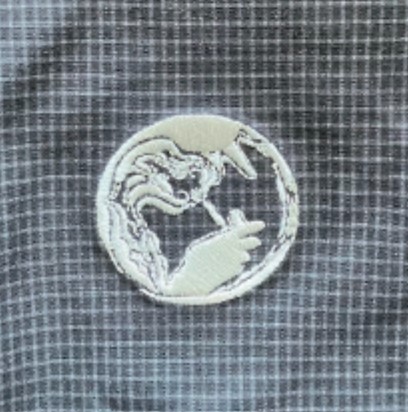 Circular white embroidery patch showing a dragon and a tiger facing each other on gray plaid fabric.