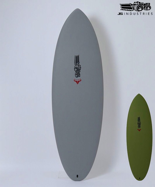 Two surfboards leaning against a white wall: a tall gray board and a shorter olive-green board, both with logos near the center, plus a JS Industries logo in the corner.