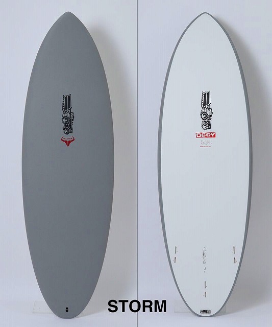 Two surfboards standing upright side by side, one gray with a black logo and red accent, the other white with a matching logo, labeled STORM at the bottom.