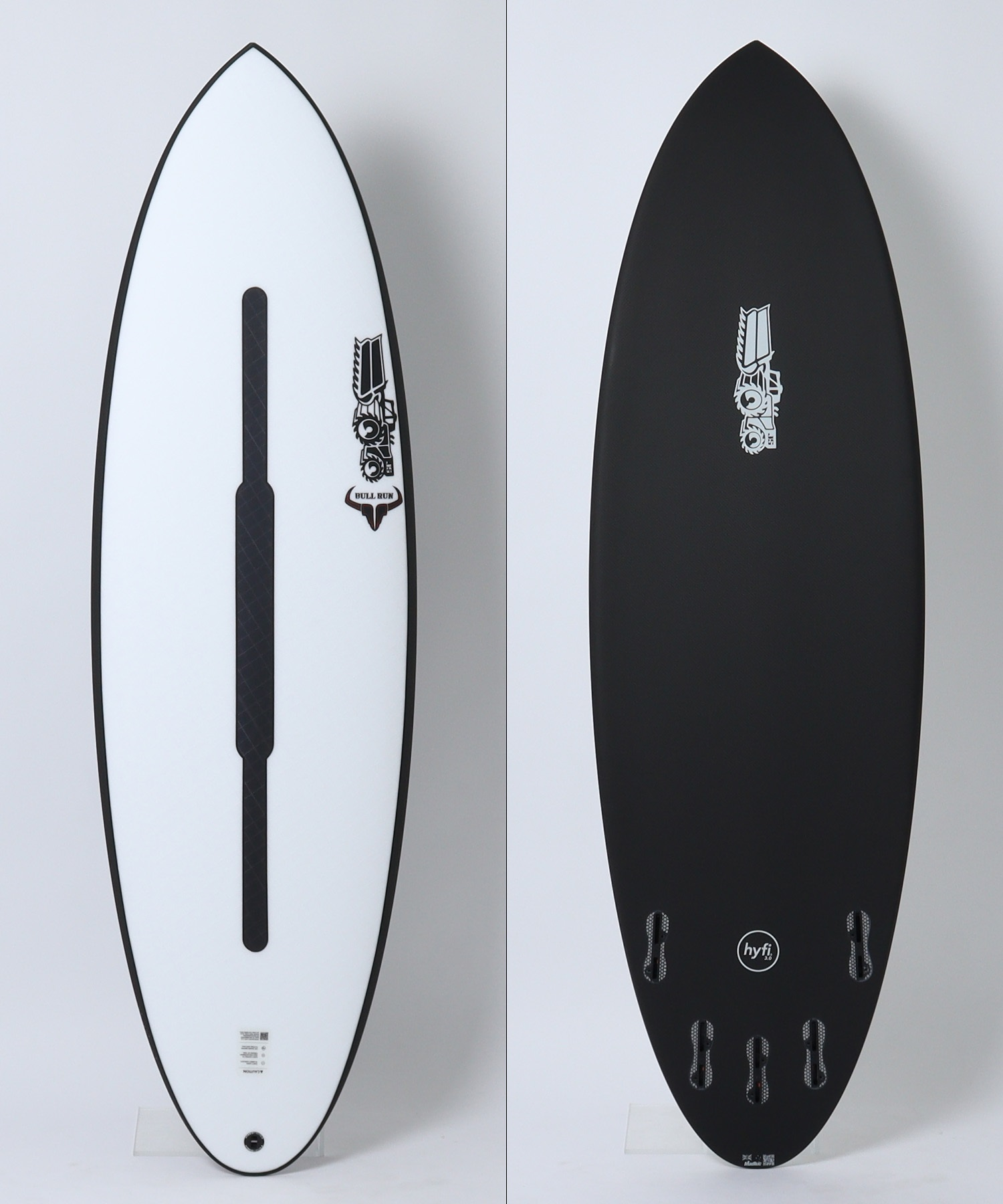 Side-by-side view of two surfboards: left a white deck with a black center channel and a Bull Run logo; right a black bottom with fin boxes and a logo.