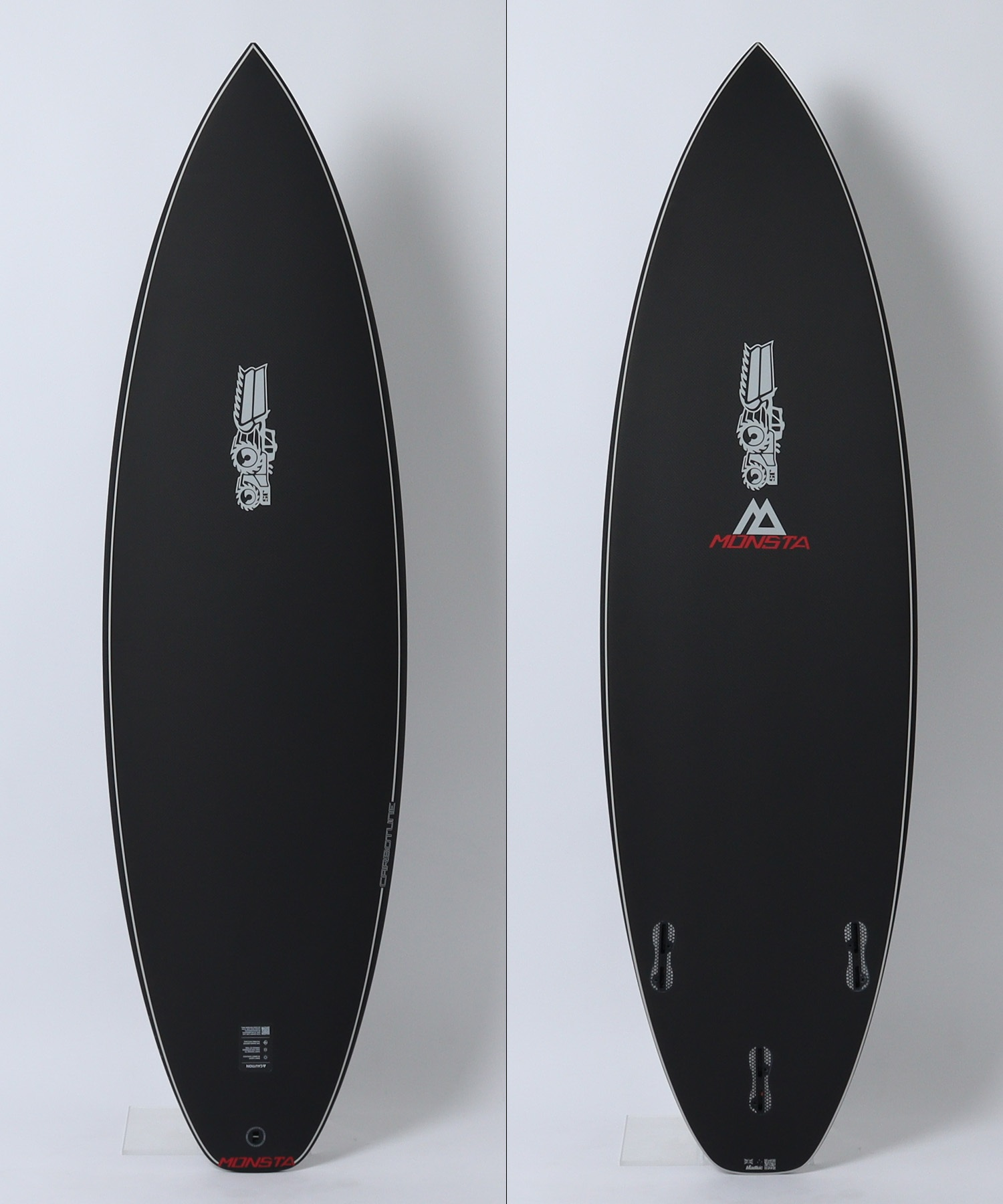Two black surfboards with white rails shown from the front, left and right panels, featuring the MONSTA logo near the bottom.