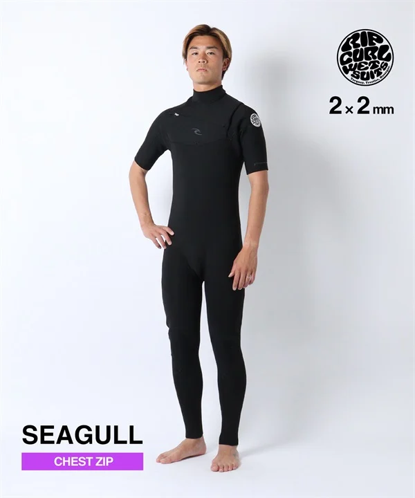 Male model wearing a black long-sleeve chest-zip wetsuit, standing with hands on hips; SEAGULL branding and chest-zip label visible
