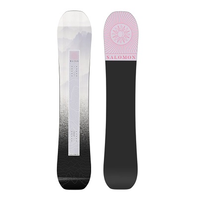 Two snowboards standing side by side; left board has a white-to-black gradient with a geometric pattern, right board has a pink tip with Salomon branding and sun motif.