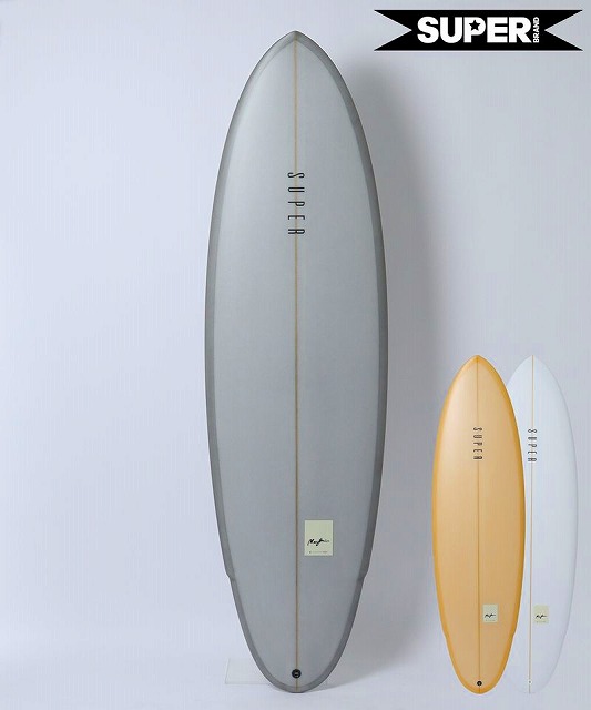 MARGIN1 - SHOP NEWS | ムラサキスポーツオンラインストア 通販 Large gray surfboard with a center stringer stands in front of two smaller boards (orange and white) on a light wall; SUPER branding visible in the top-right corner.